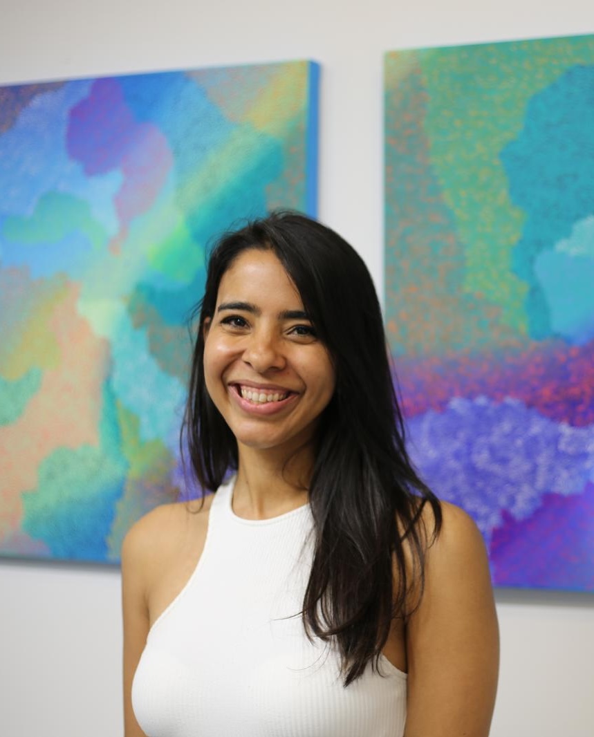 Osmeli Delgado in front of her paintings